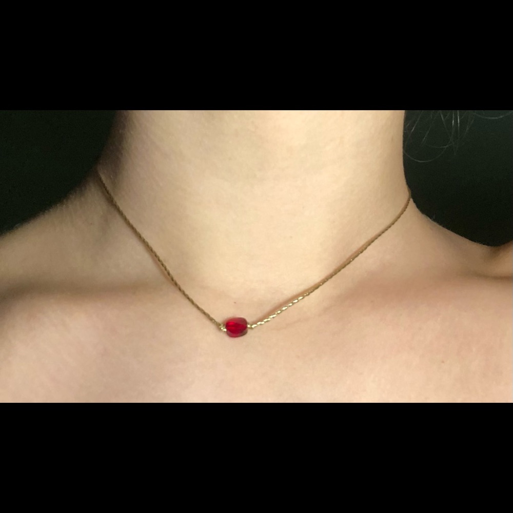 Gold choker with dark red stone